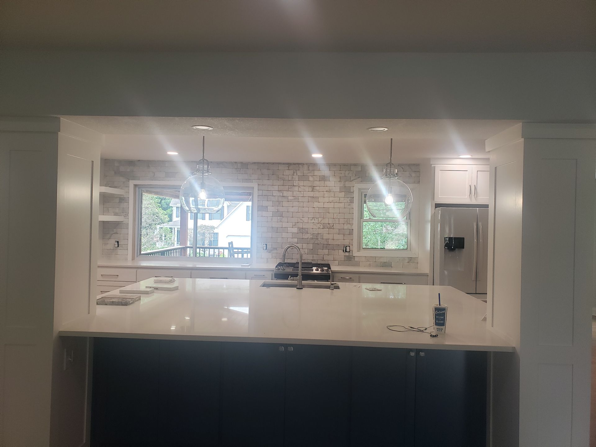 A kitchen with a large island and a refrigerator.