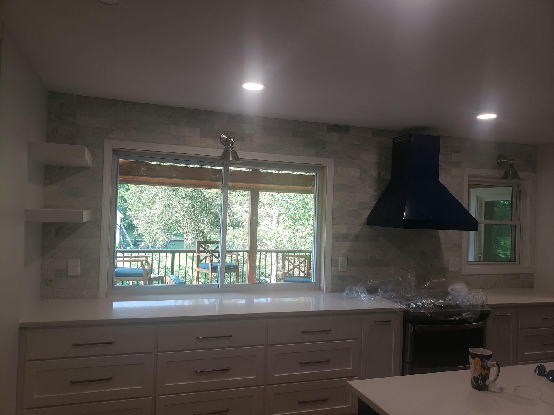A kitchen with white cabinets and a large window