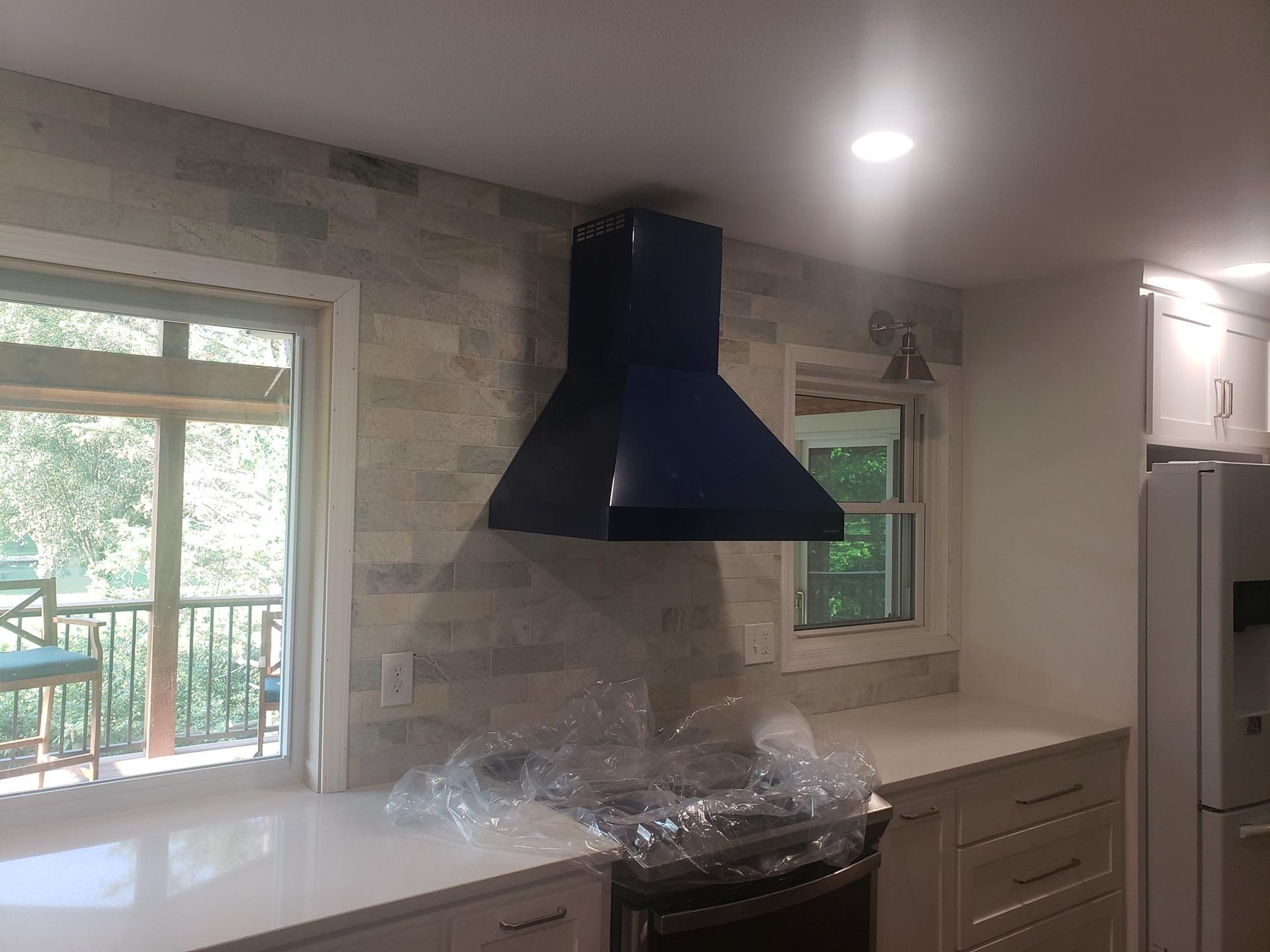 A kitchen with a blue hood and a window.