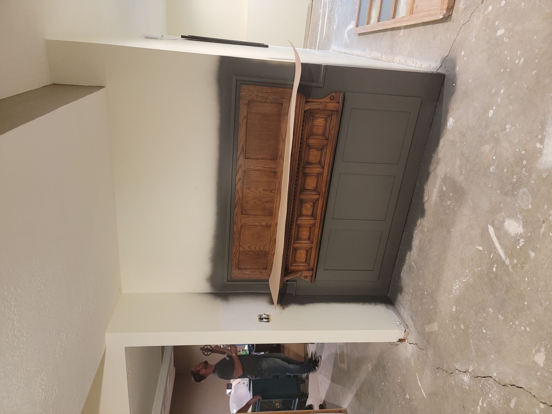 A man is painting a door in a room.