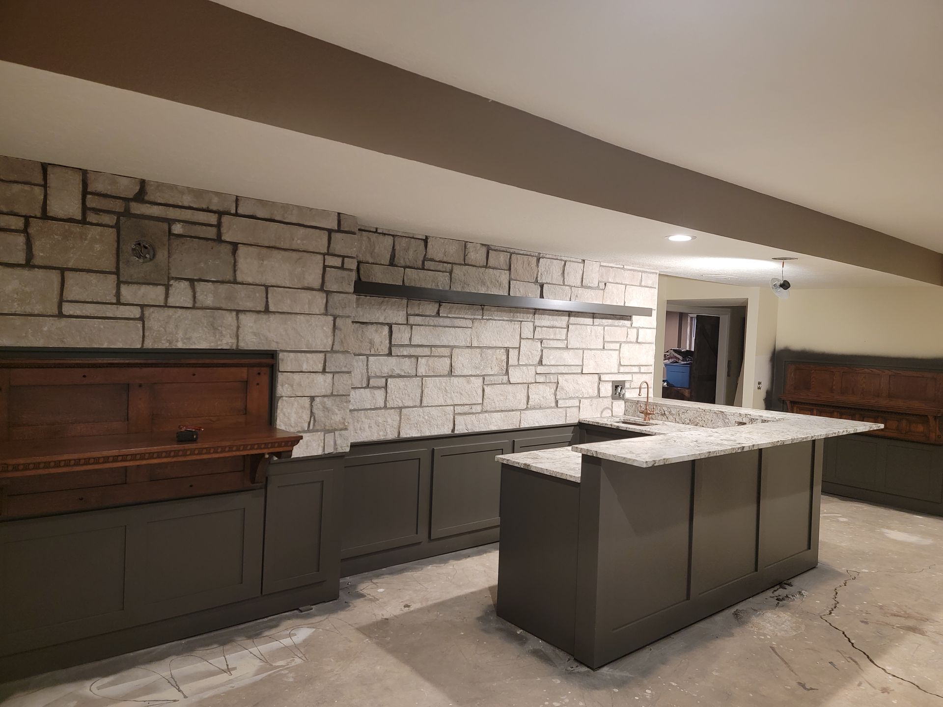 A kitchen with a large island and a stone wall.