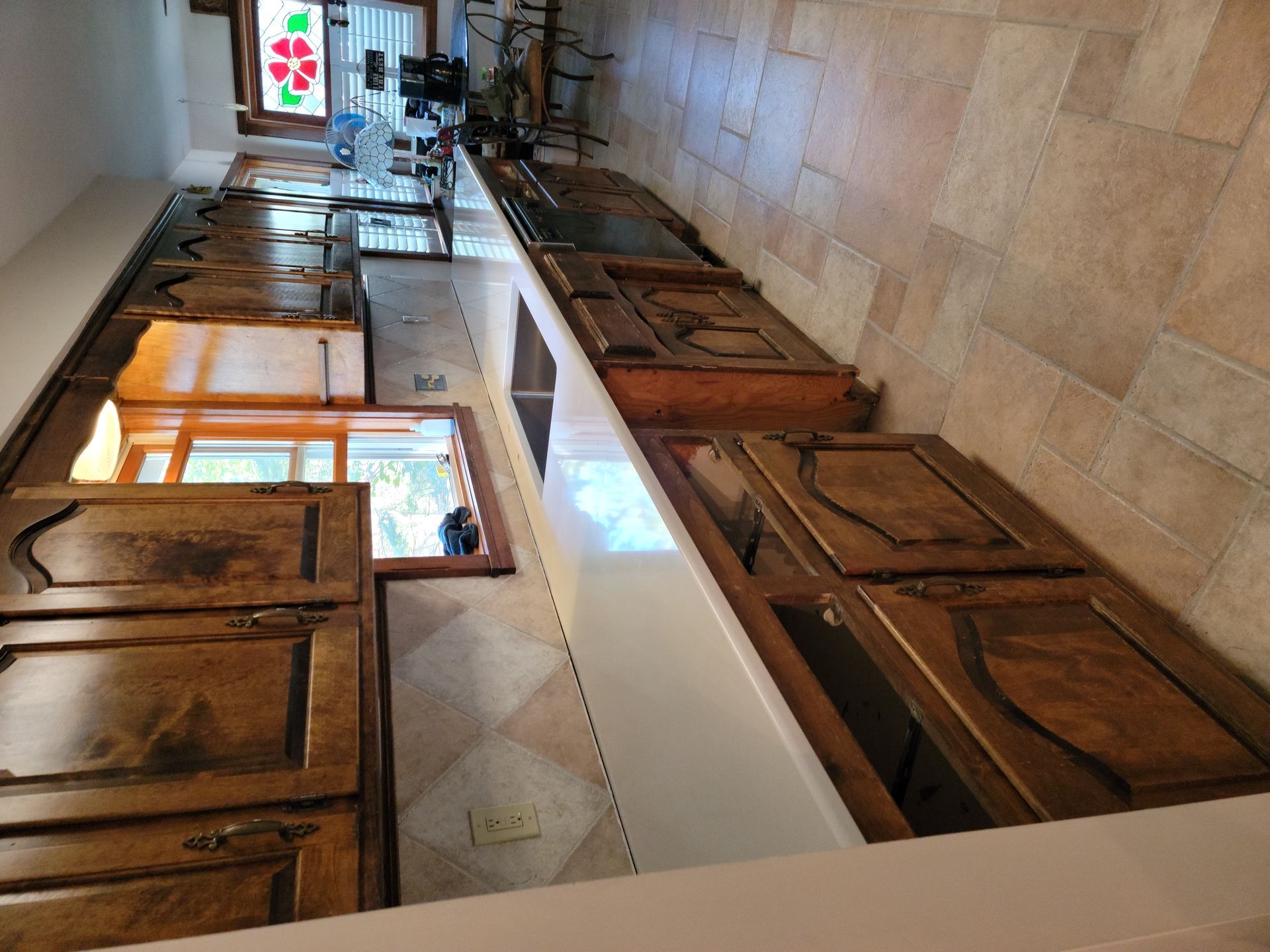 A kitchen with wooden cabinets and a tiled floor