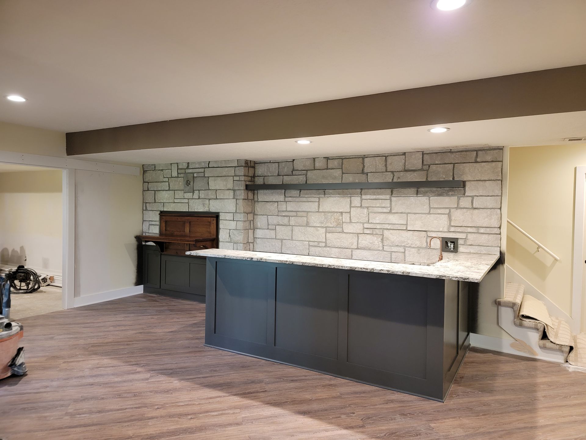 A basement with a bar and a brick wall.