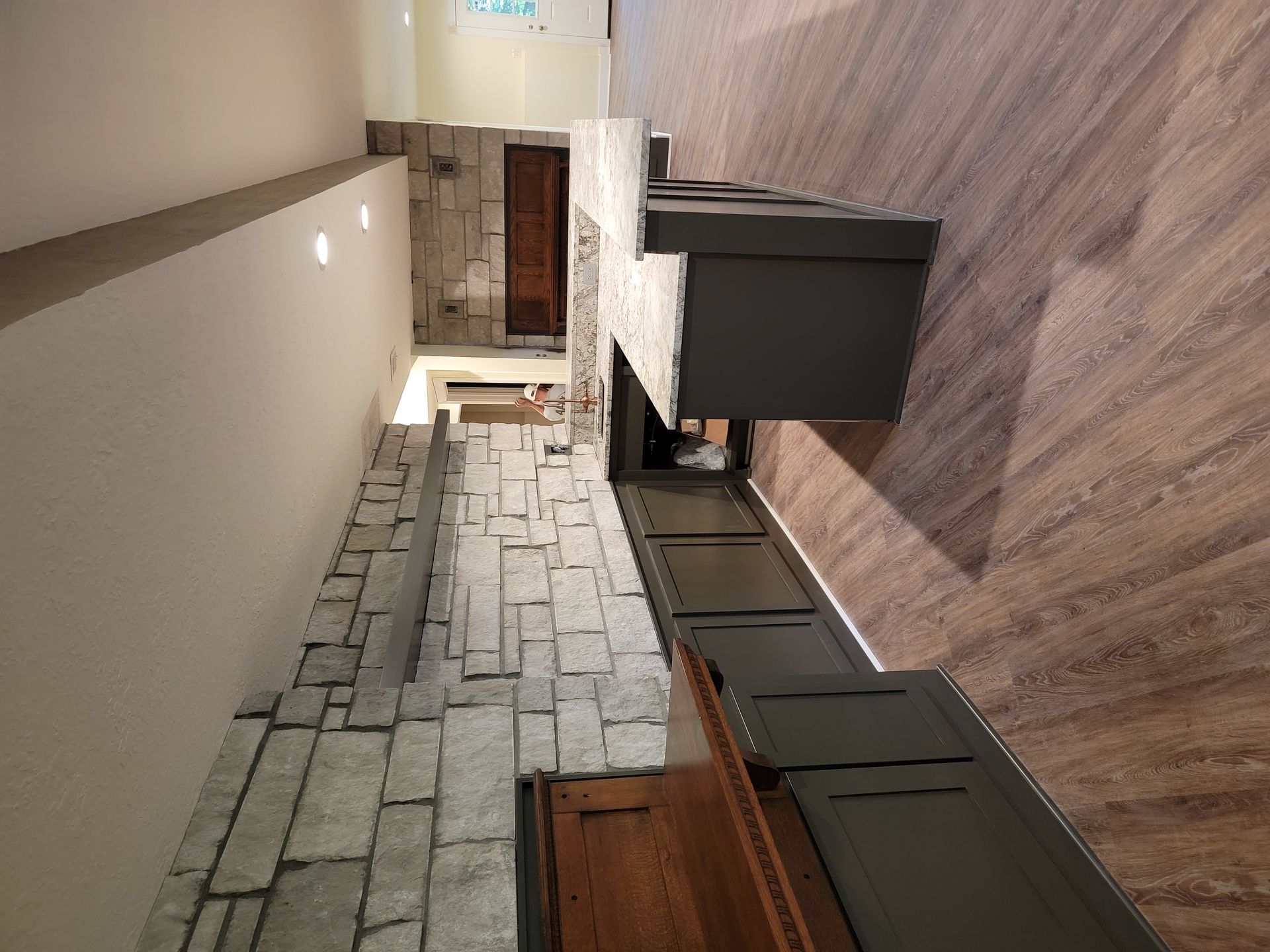 A living room with a fireplace and a stone wall.