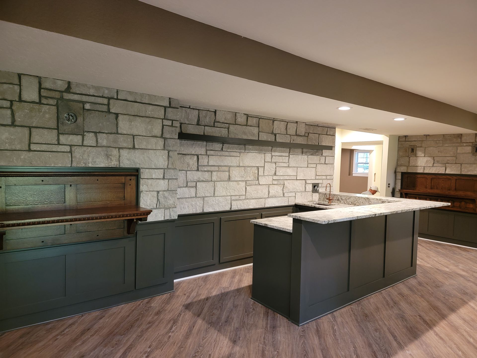 A kitchen with a large island and a stone wall.