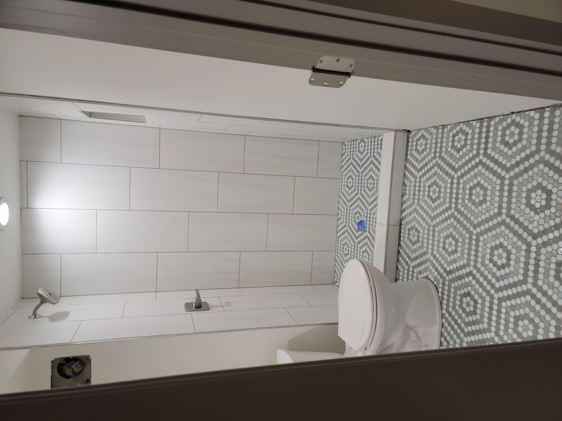 A bathroom with a toilet , sink and shower.