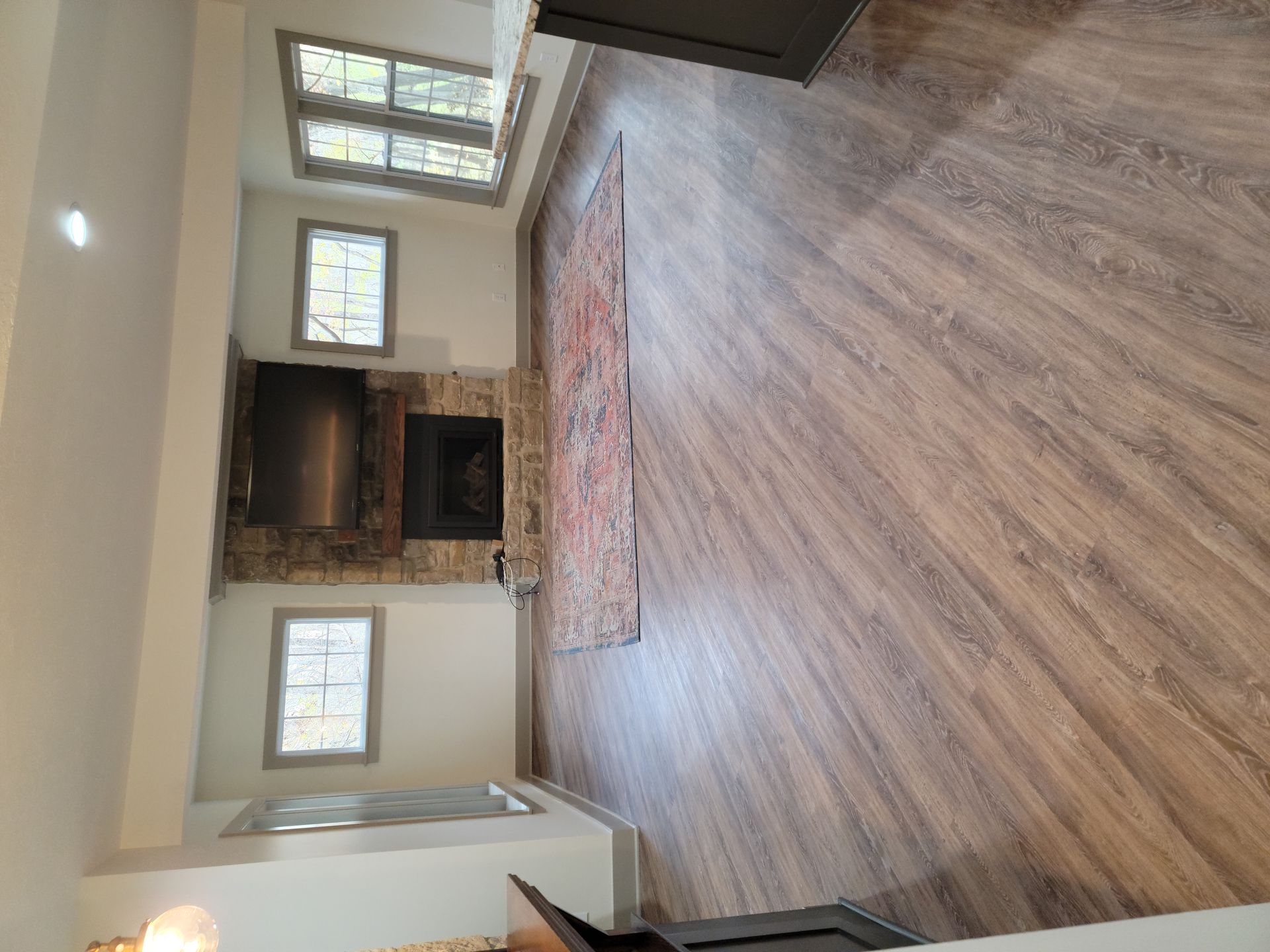 A living room with hardwood floors and a fireplace.