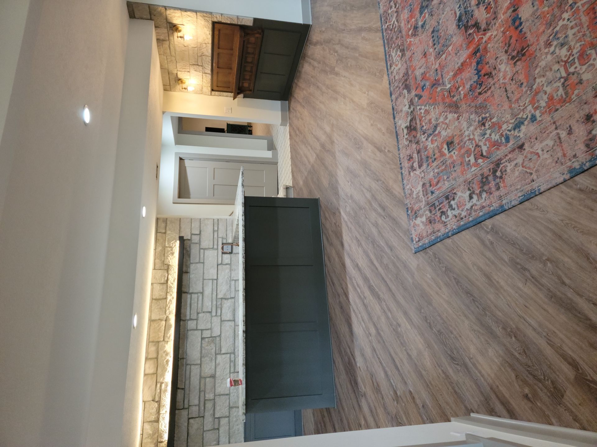 A living room with hardwood floors and a rug.