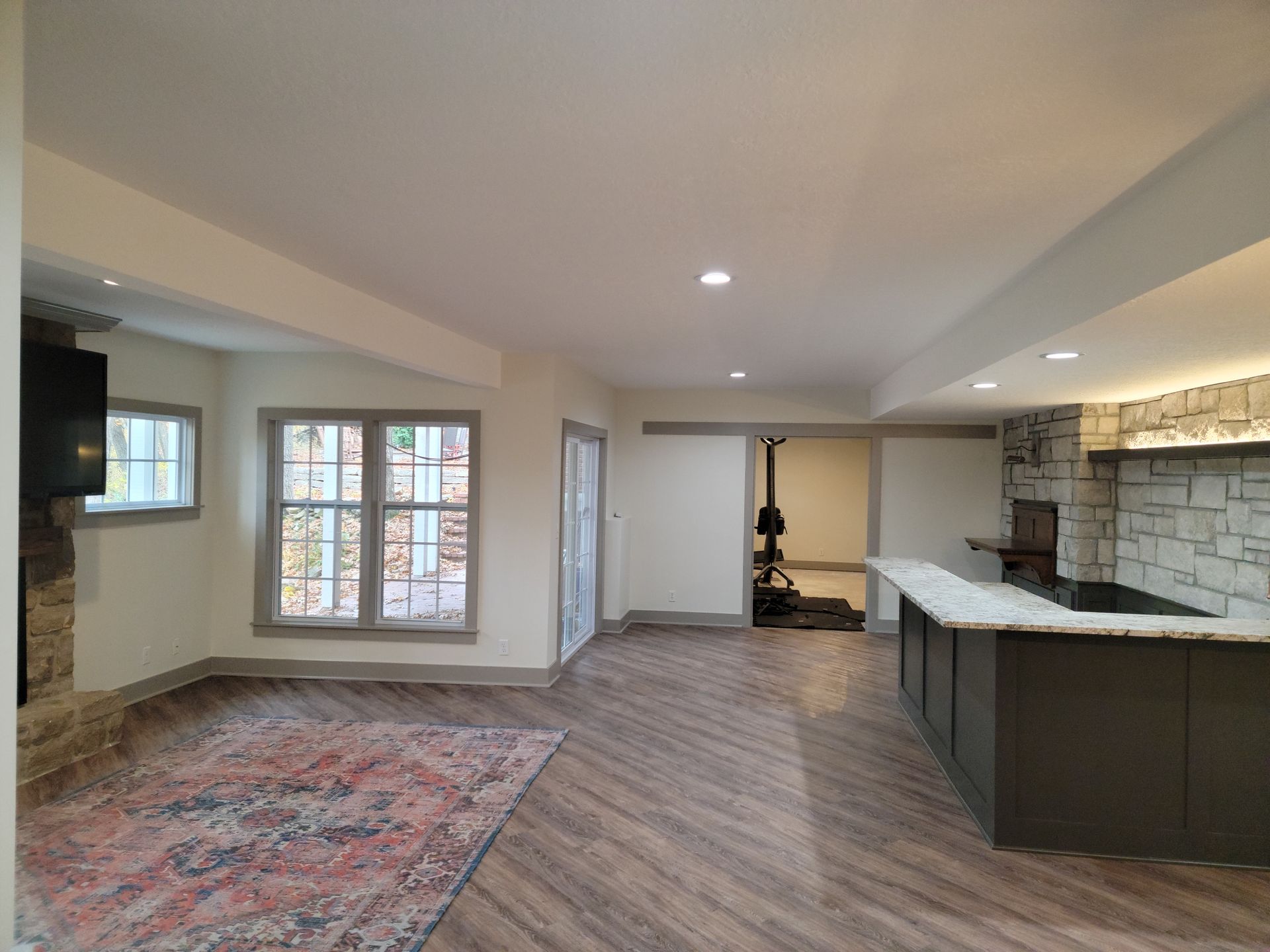 A living room with hardwood floors , a fireplace and a television.