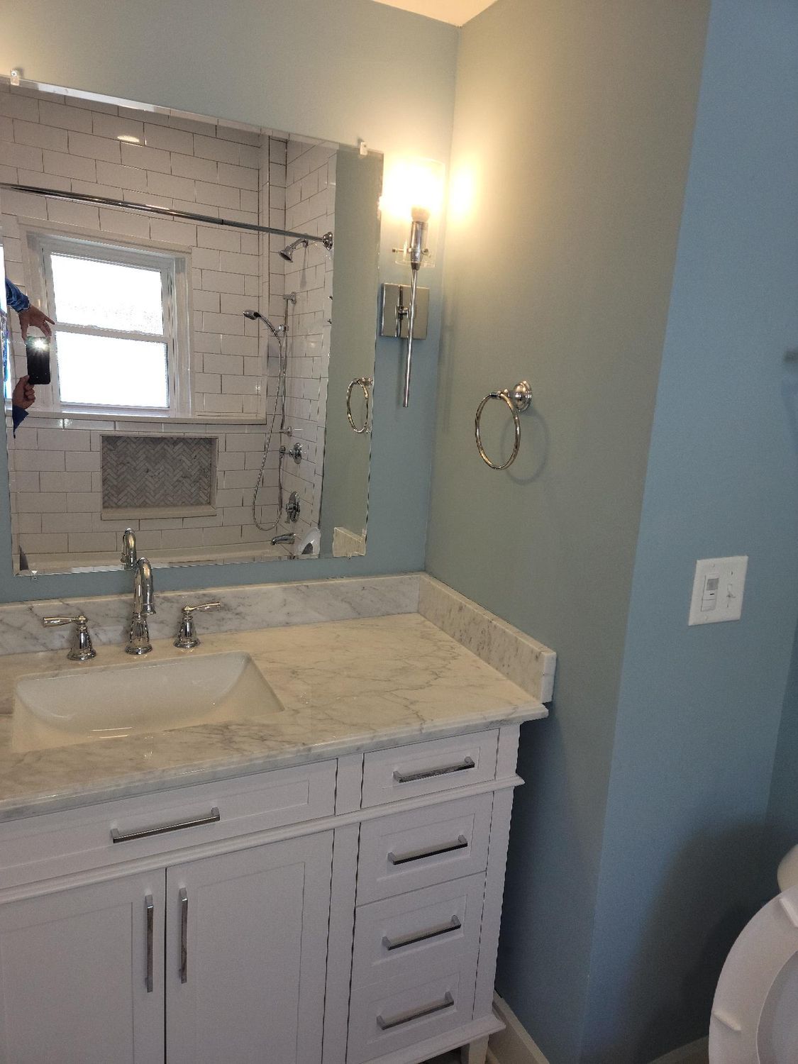 A bathroom with a sink , mirror and toilet