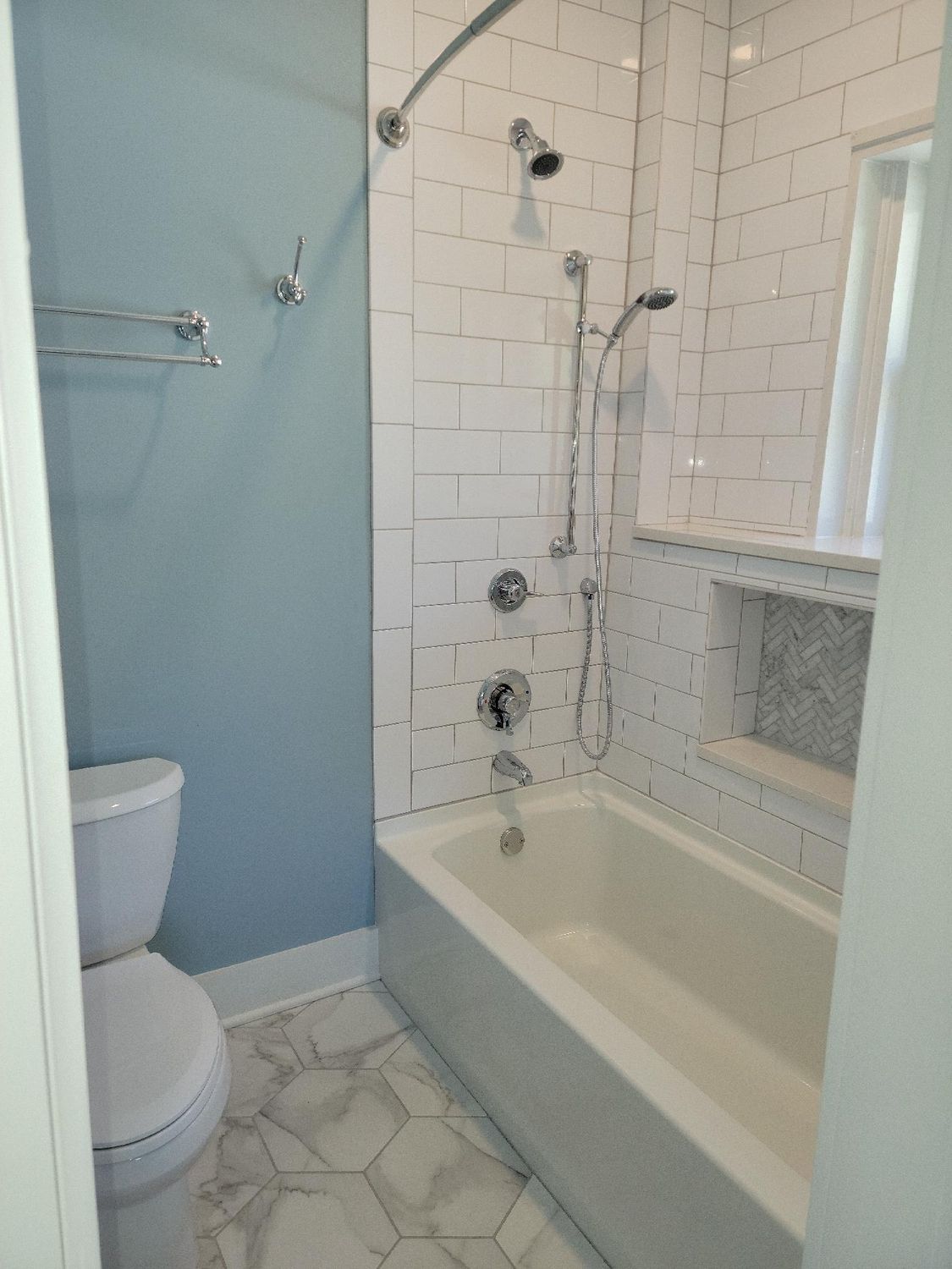 A bathroom with a toilet , bathtub and shower.