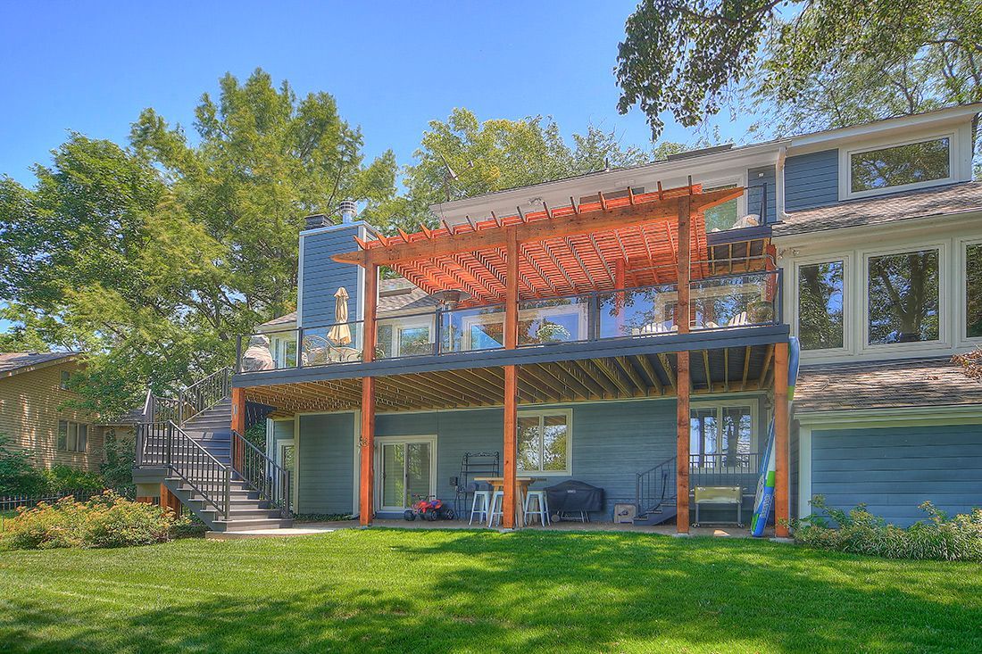 The back of a house with a large deck and a pergola.