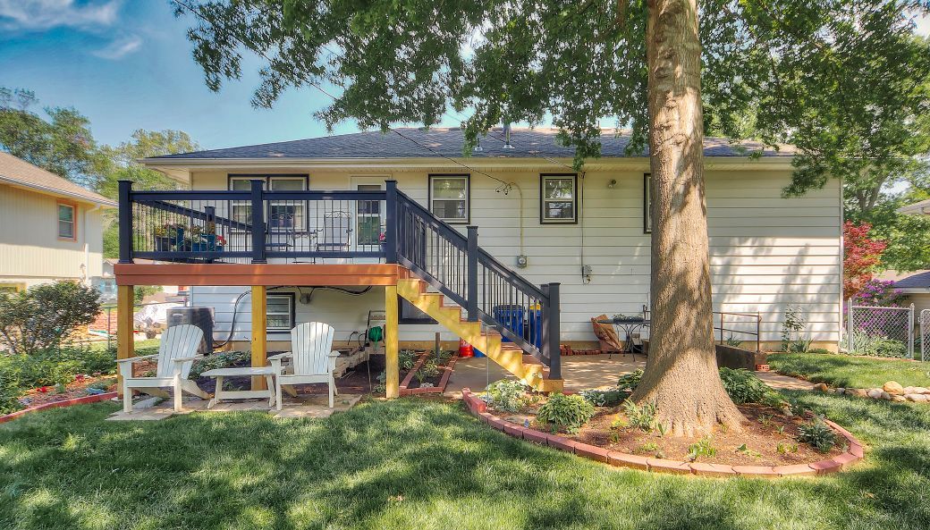 A house with a deck and stairs in the backyard.