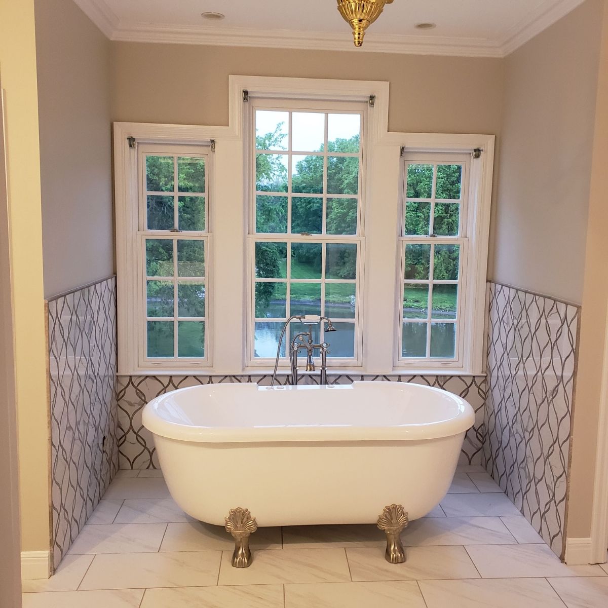 A bathtub with claw feet in a bathroom next to a window