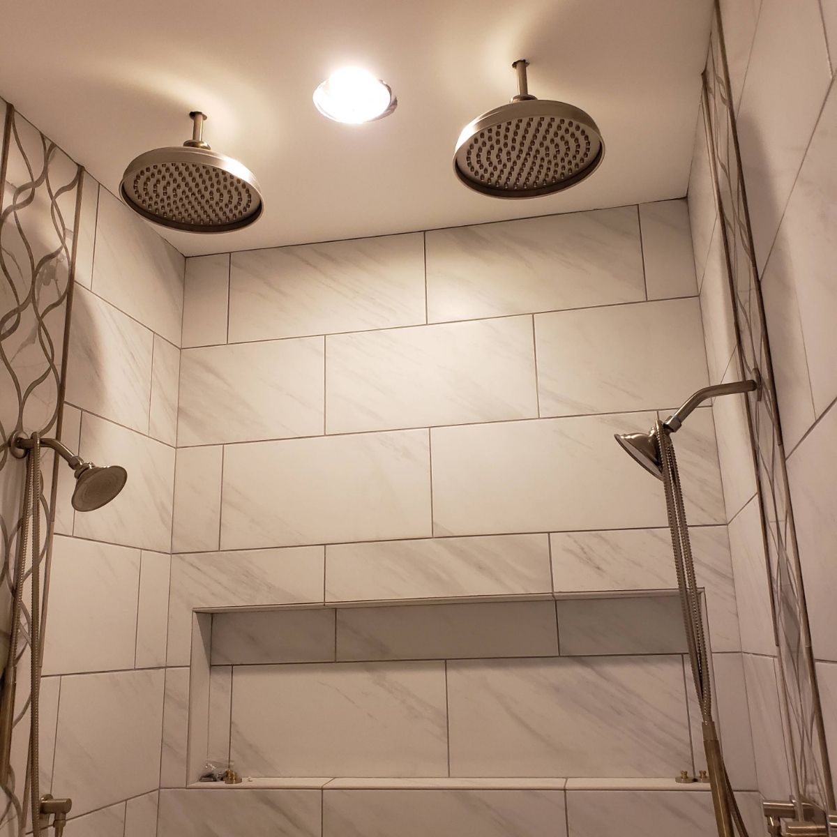 A bathroom with two shower heads hanging from the ceiling