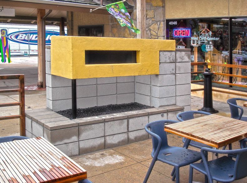 A patio area with tables and chairs and a sign that says open