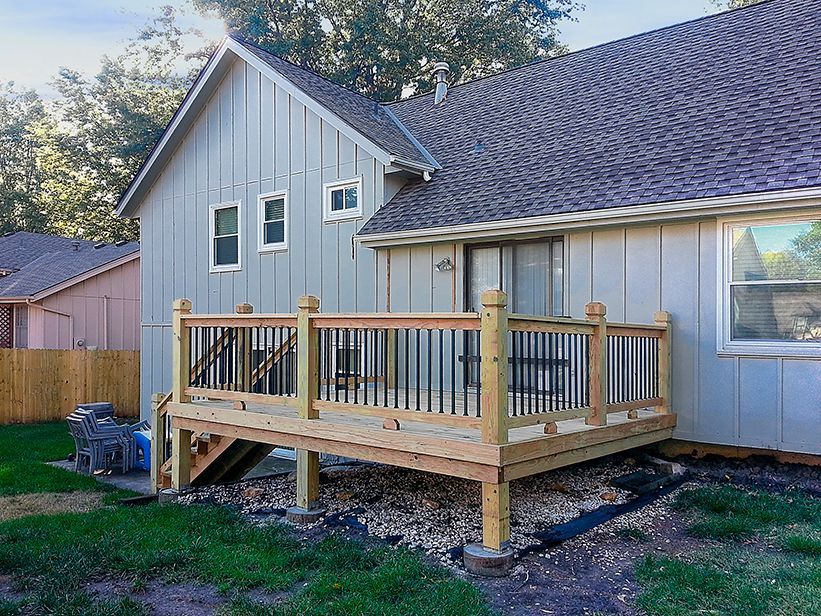 A house with a wooden deck in the backyard.