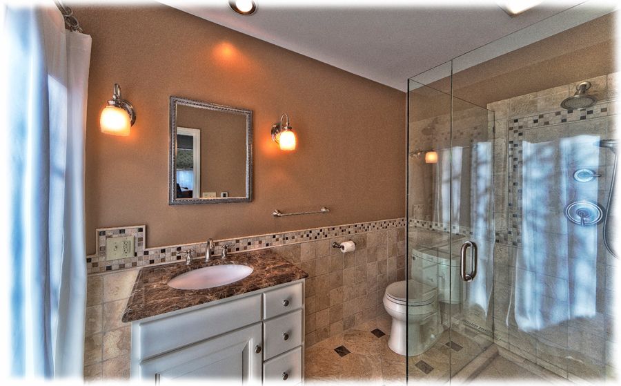 A bathroom with a sink a toilet and a walk in shower