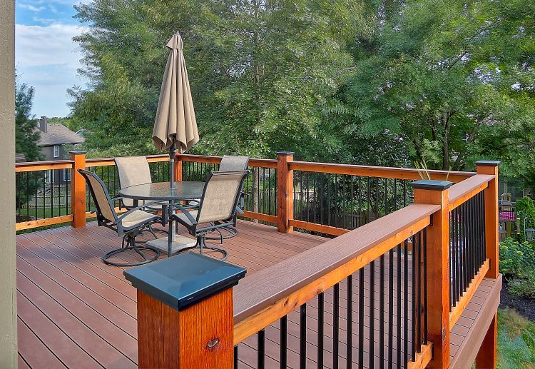A wooden deck with a table and chairs and an umbrella.