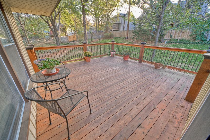 A wooden deck with a table and chairs on it.