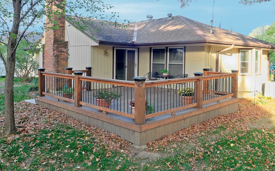 A house with a wooden deck in front of it.