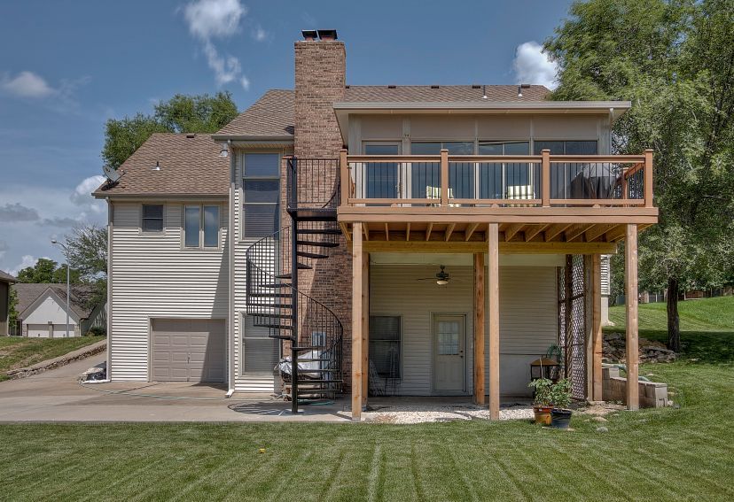 The back of a house with a large deck and stairs