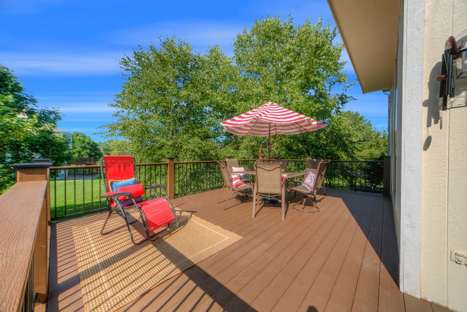 A deck with a table and chairs and an umbrella.
