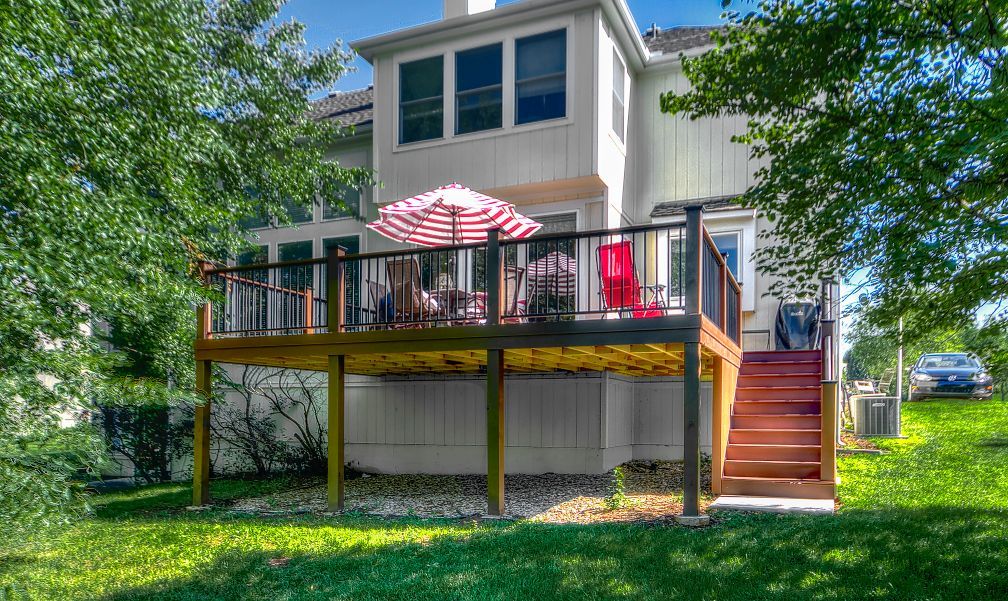 The back of a house with a large deck and stairs.