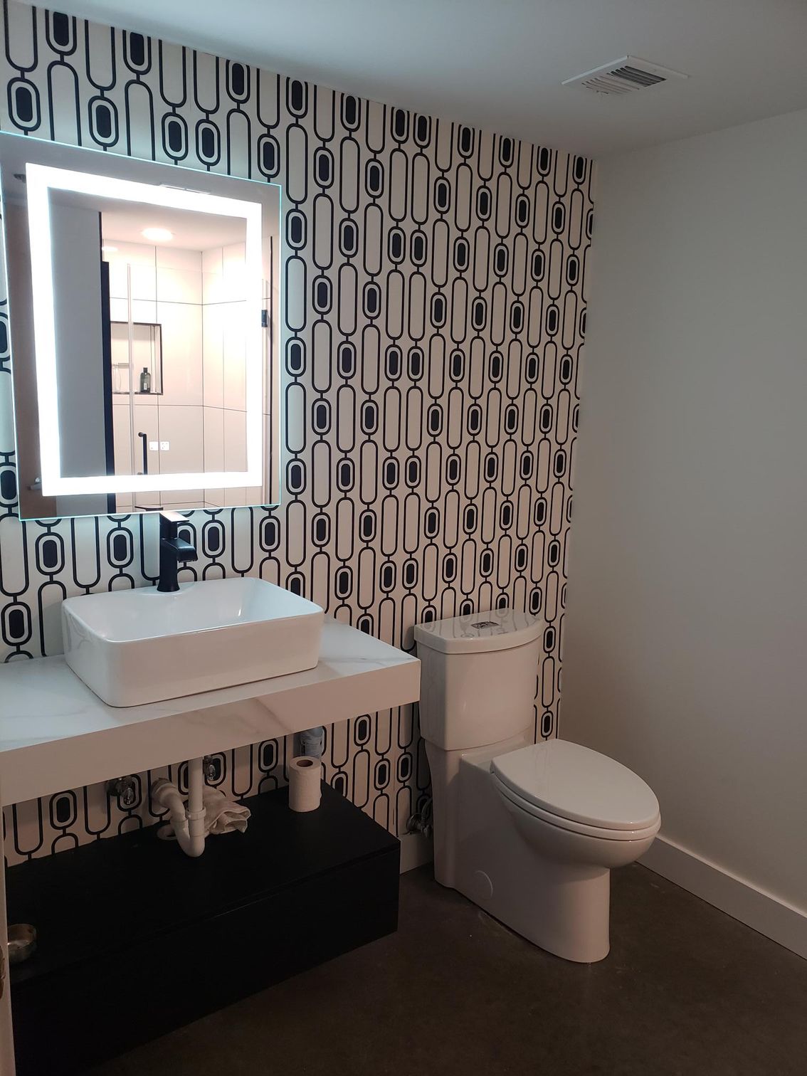 A bathroom with a toilet a sink and a mirror