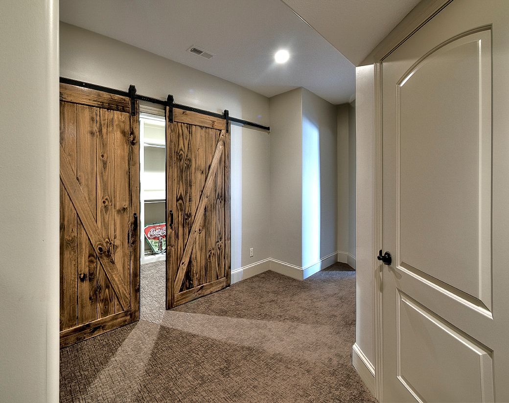 A hallway with sliding barn doors and a carpeted floor.