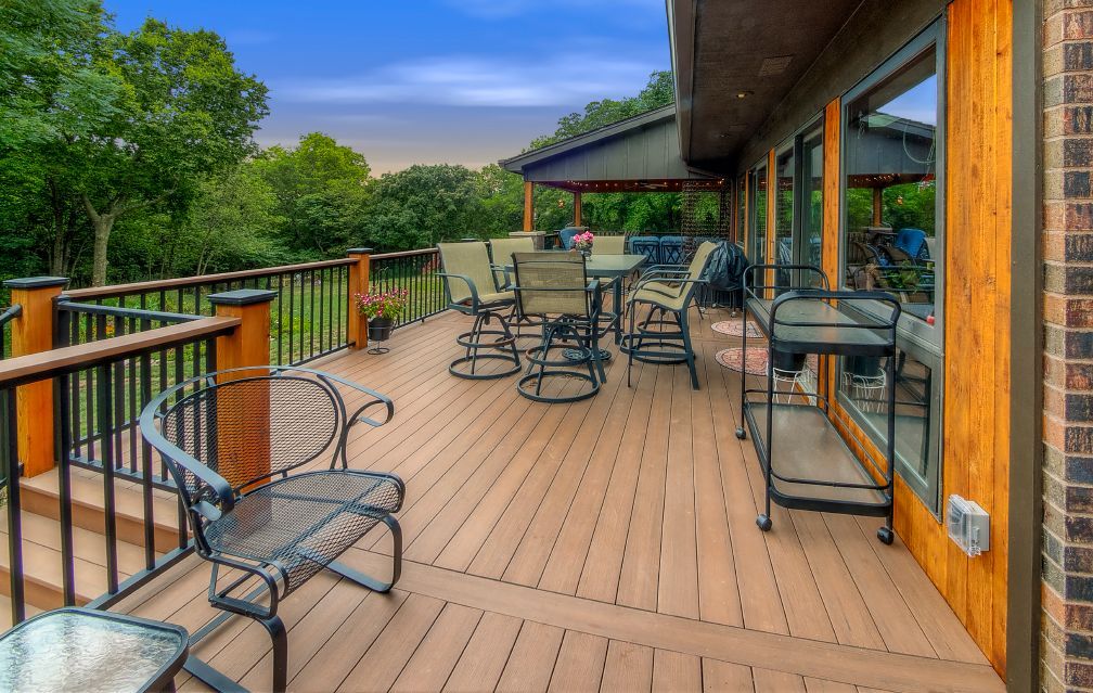A large wooden deck with a table and chairs on it.