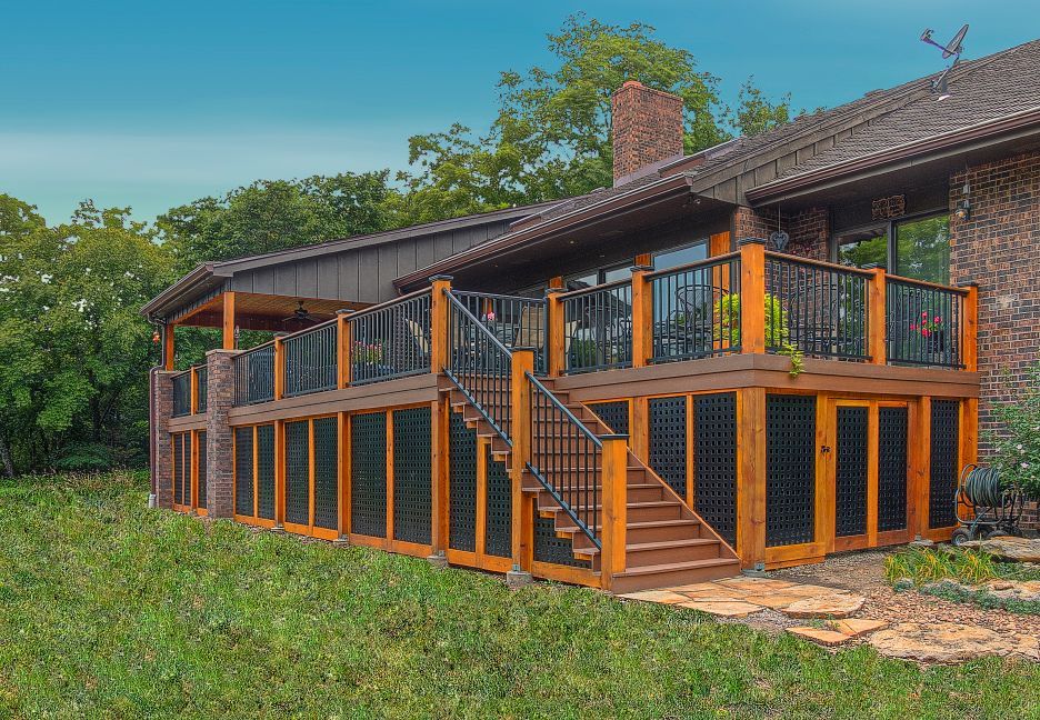 A large house with a large wooden deck and stairs