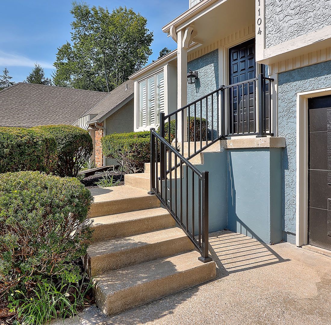 A blue house with stairs leading up to the front door