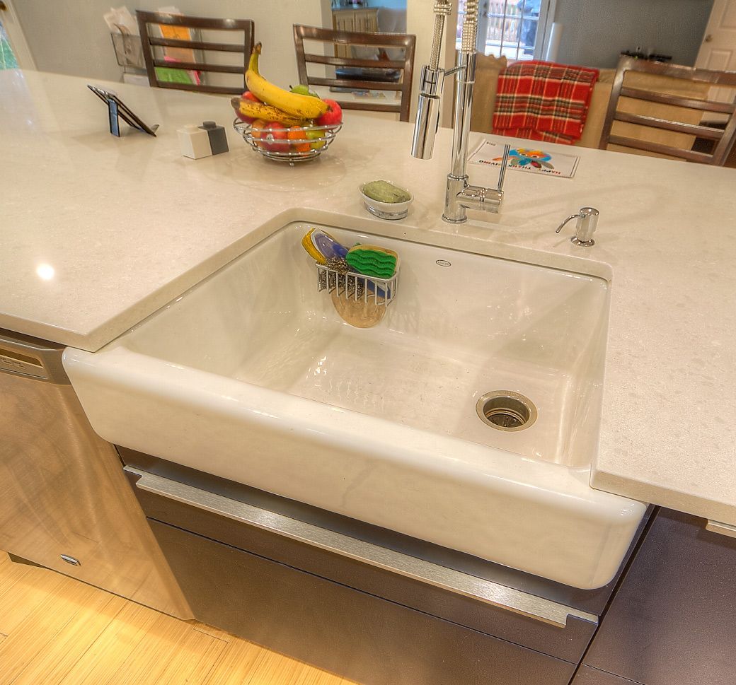 A kitchen sink with a bowl of bananas in it