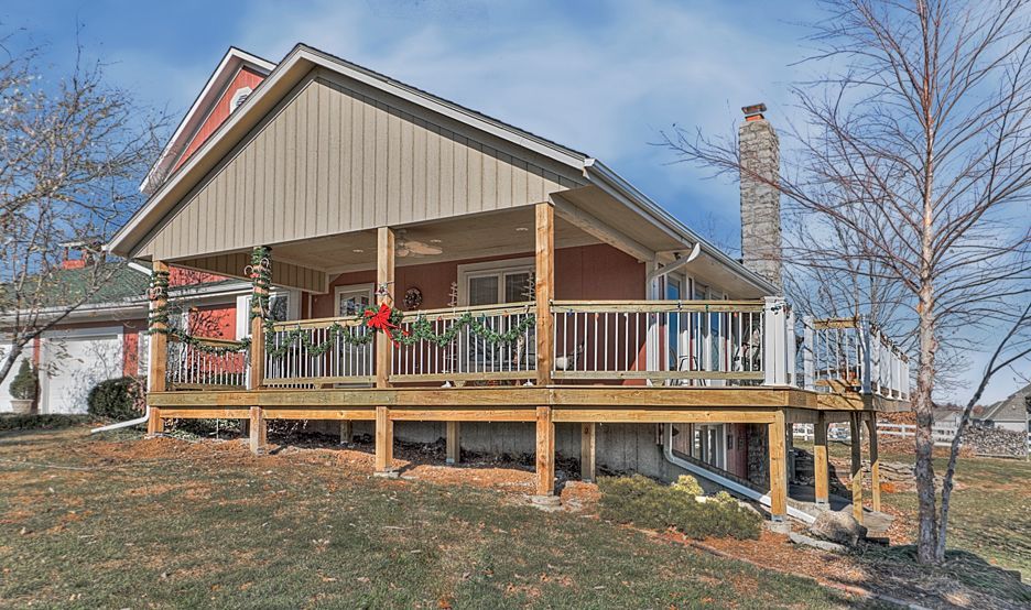A house with a large porch and a wooden deck.