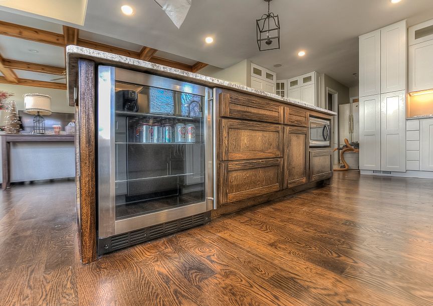 A kitchen with wooden cabinets and a stainless steel refrigerator.