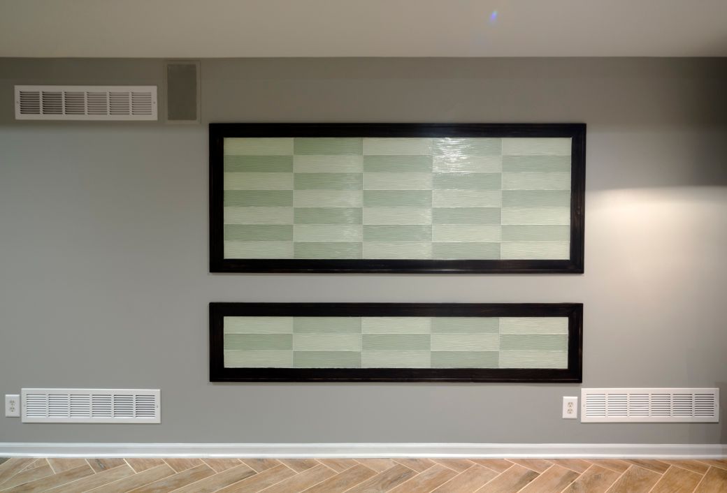 An empty room with two framed pictures on the wall.