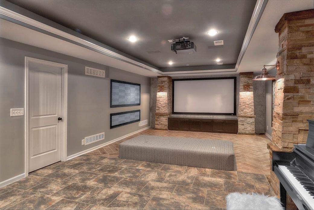 A basement with a projector screen and a piano.