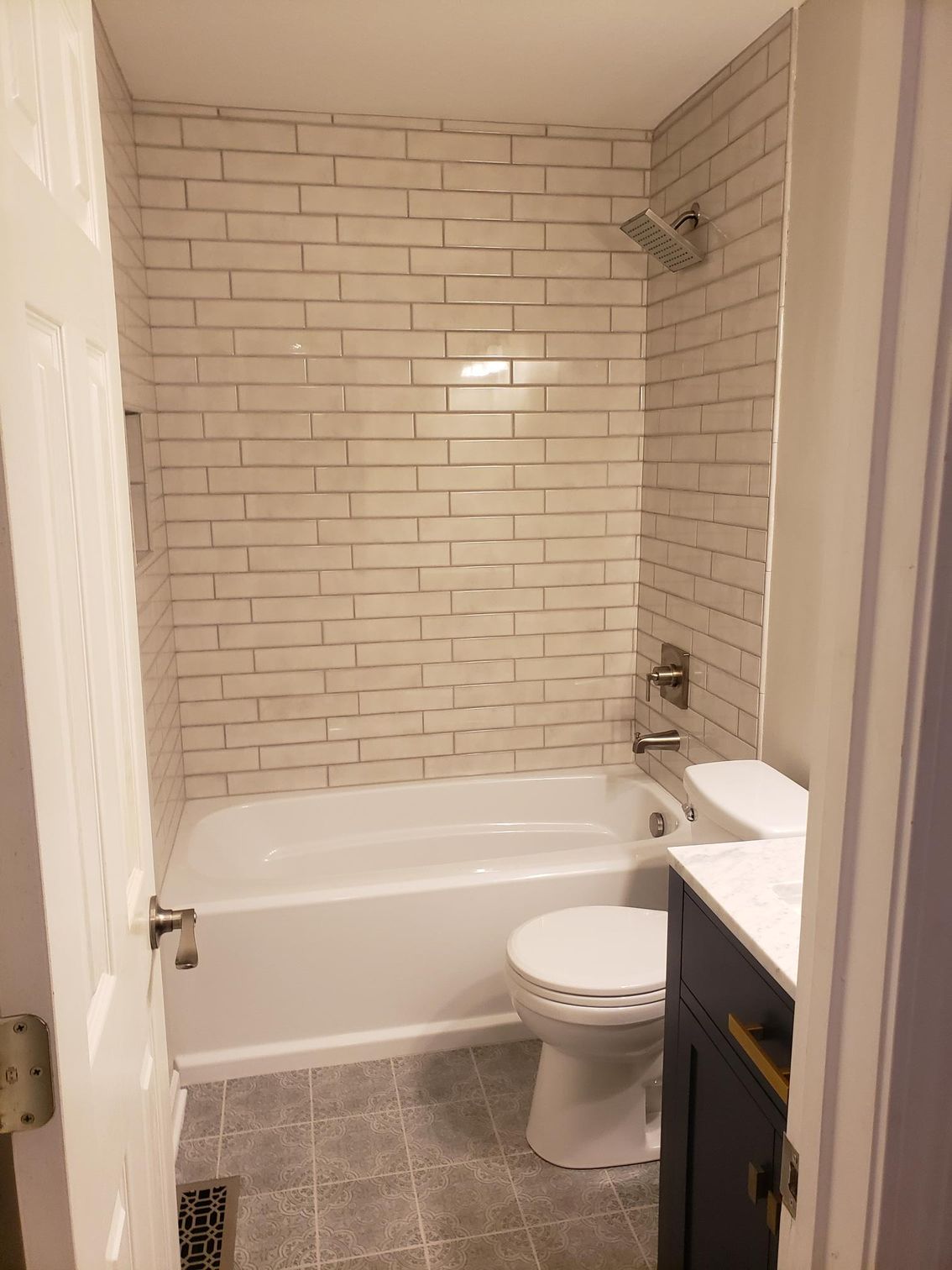 A bathroom with a tub , toilet , sink and shower.