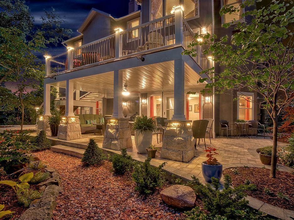 A large house with a large porch and patio at night.