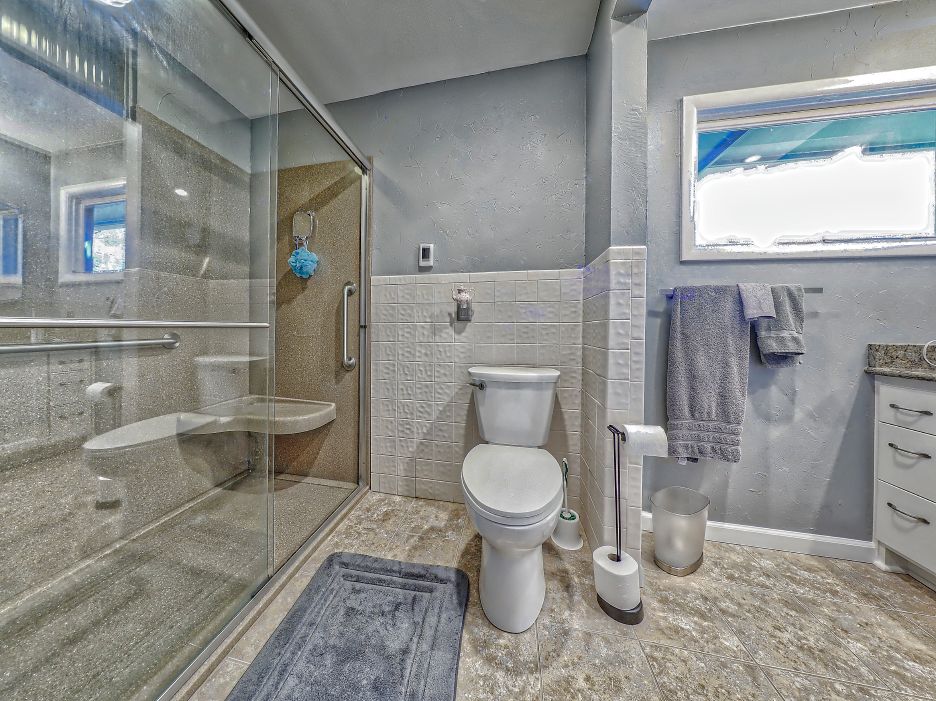 A bathroom with a toilet , sink , and shower.
