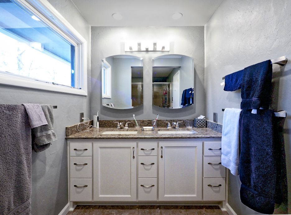 A bathroom with two sinks and two mirrors.