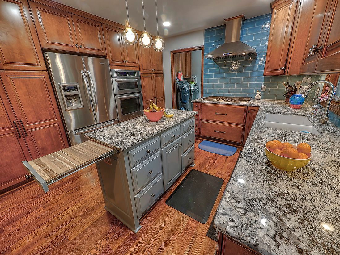 A kitchen with granite counter tops and stainless steel appliances.