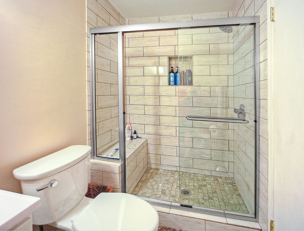 A bathroom with a toilet and a walk in shower