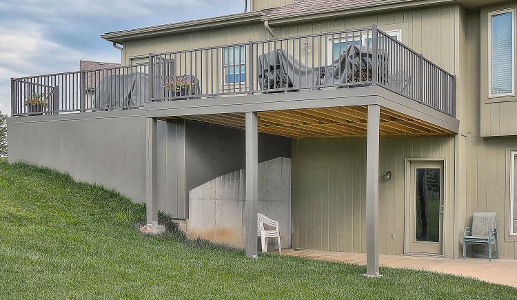 A large house with a large deck and stairs leading up to it.