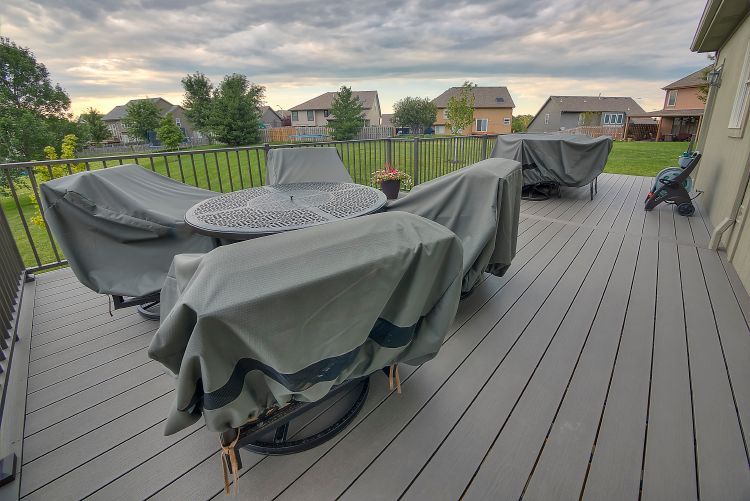 A deck with a table and chairs covered in covers.