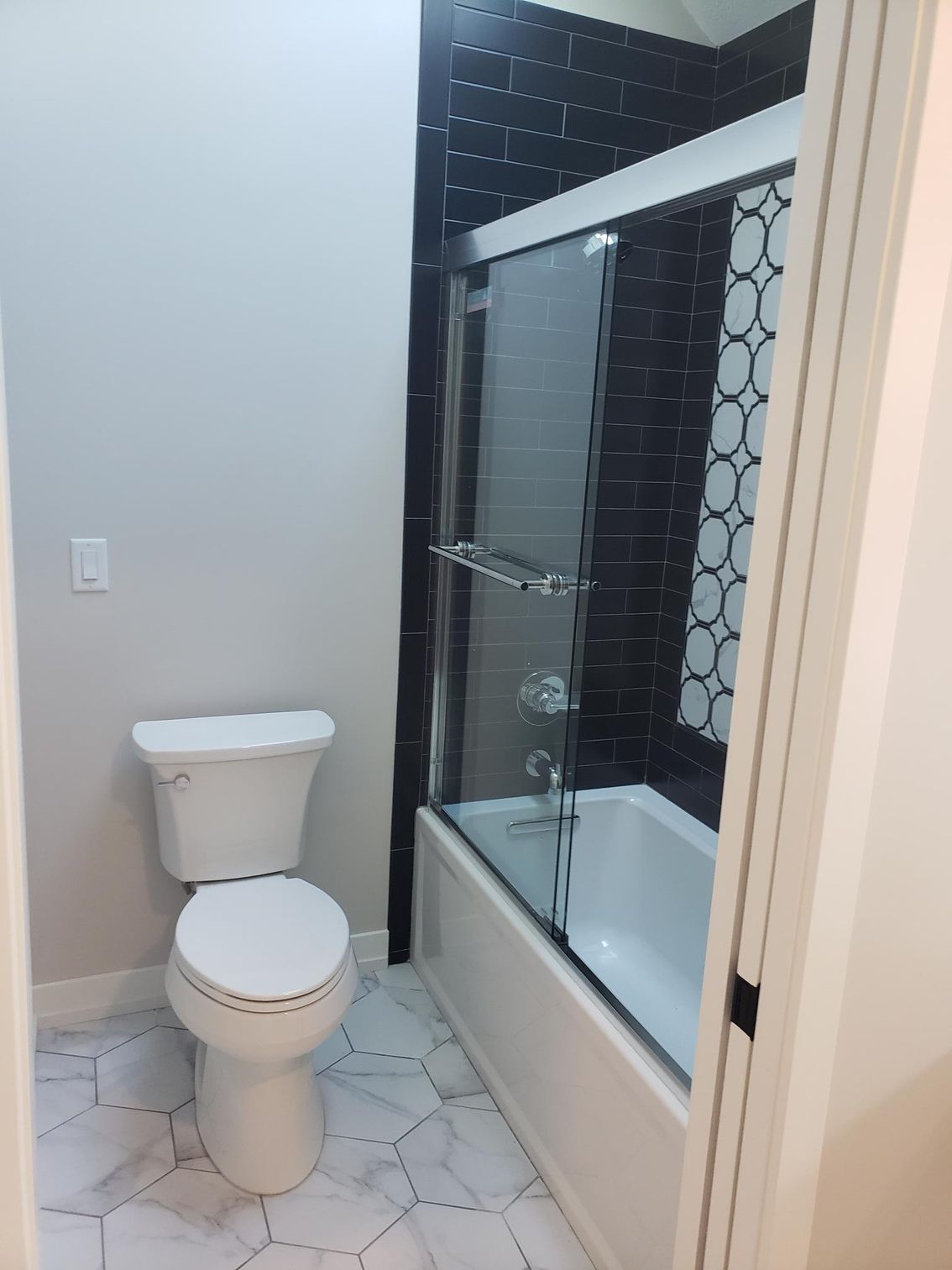 A bathroom with a toilet , tub and shower.