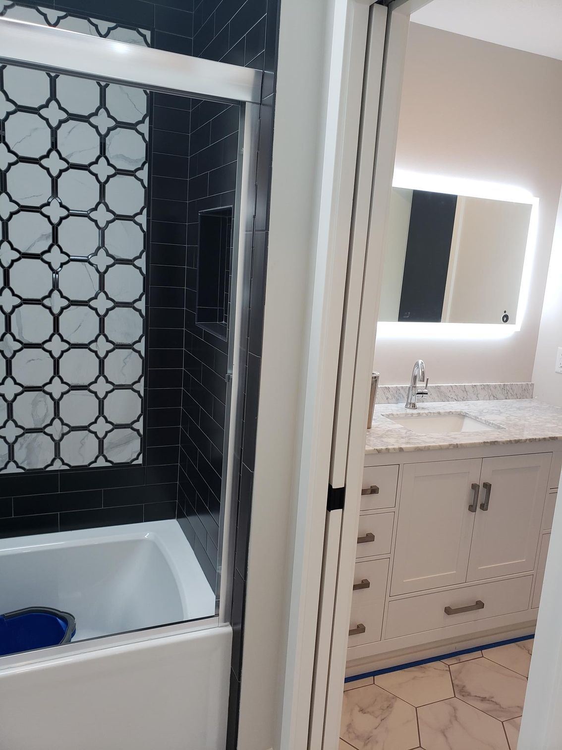 A bathroom with a bathtub , sink and mirror