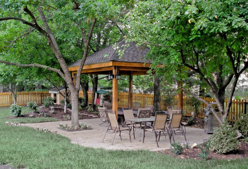 There is a gazebo with a table and chairs underneath it.