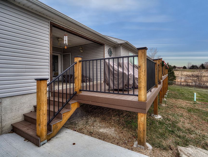 A house with a deck and stairs in front of it